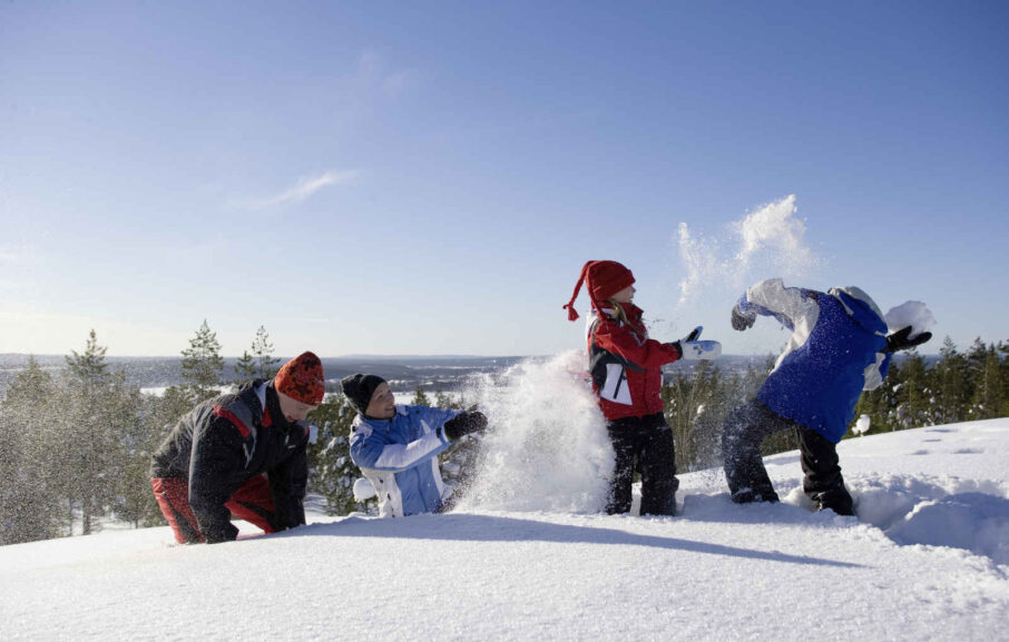 Famlille jouant dans la neige Laponie Finlande