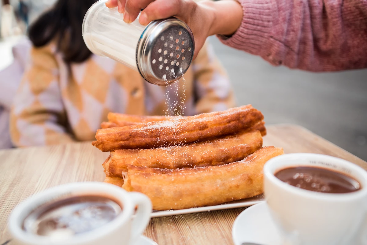 Churros au sucre avec du chocolat chaud
