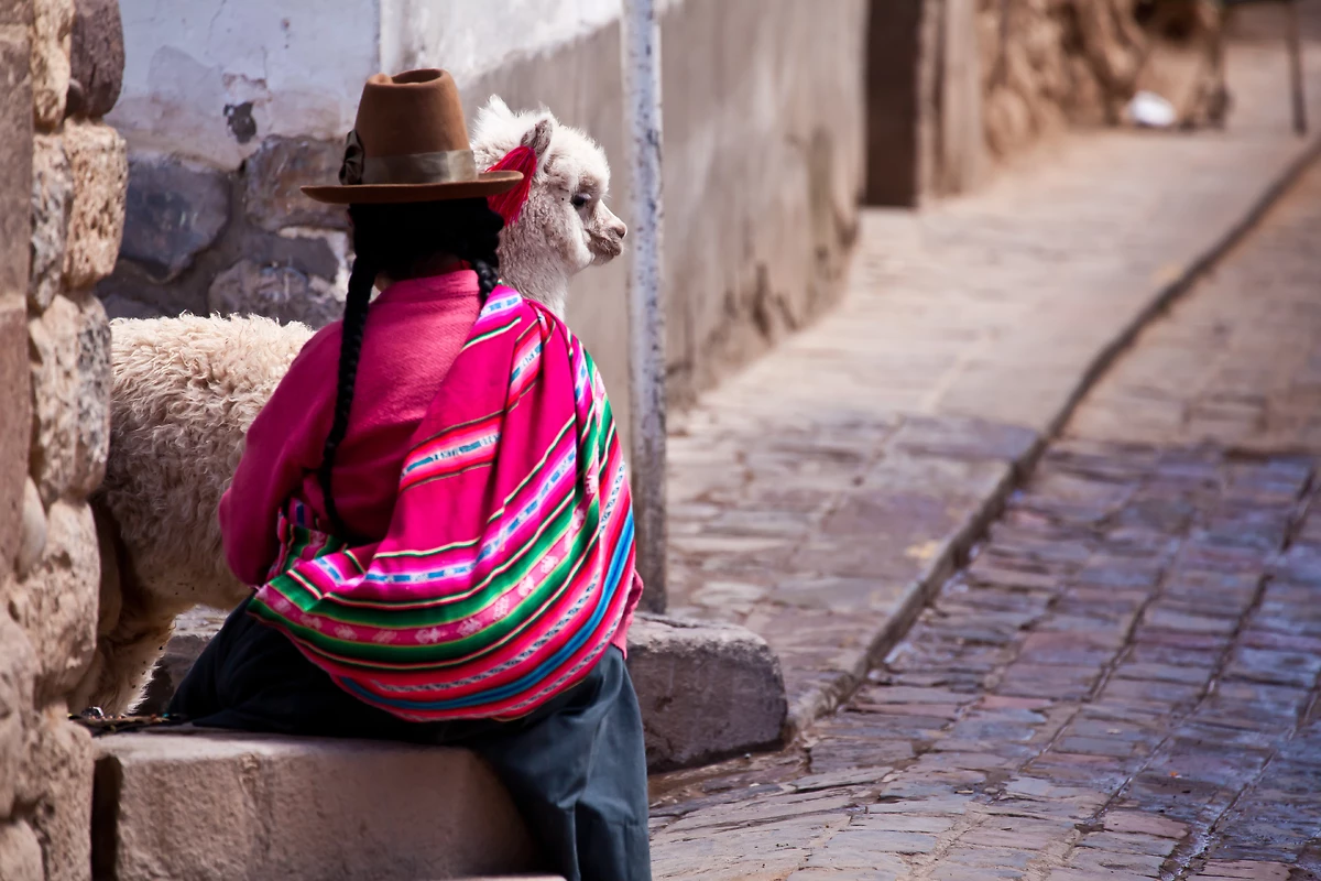 Femme et lama dans une ruelle de Cuzco, Pérou